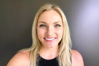 Headshot of Karly Quaack, Ph.D., a young, white woman with long blonde hair wearing a black tank top and smiling at the camera.