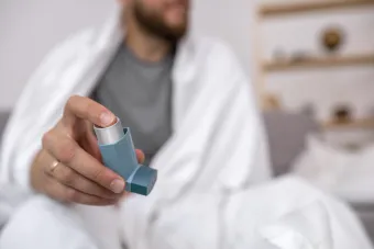 man holding out asthma inhaler