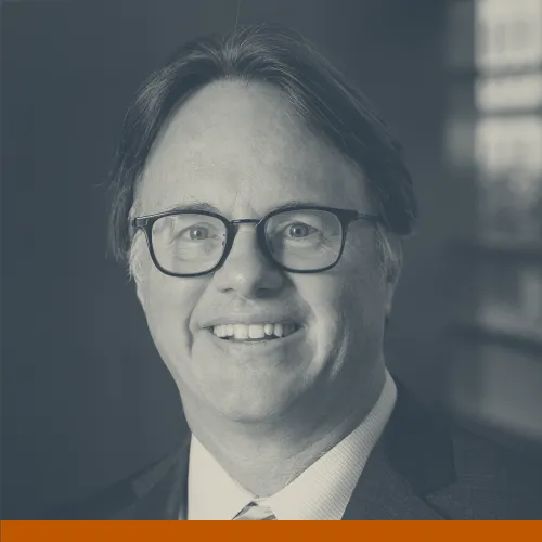 Headshot of David Lakey, M.D., a older white man with short, dark hair wearing glasses and a suit and smiling at the camera.