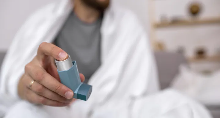 man holding out asthma inhaler